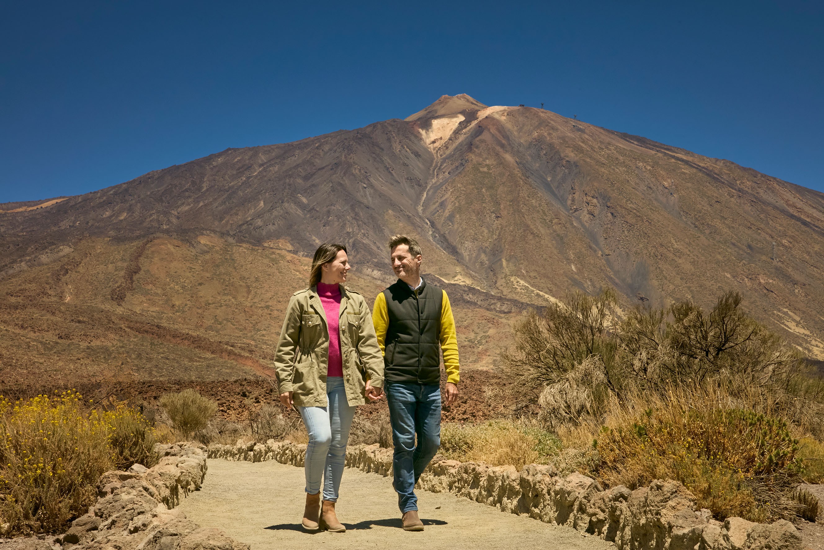 Koppel genietend van het uitzicht met Teide op de achtergrond tijdens de exclusieve VIP Teide Tour Koppel genietend van het uitzicht met Teide op de achtergrond tijdens de exclusieve VIP Teide Tour
